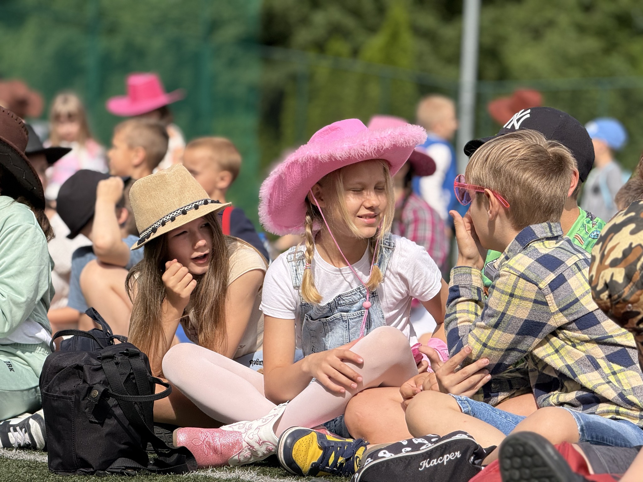 Dzieci siedzą na trawie