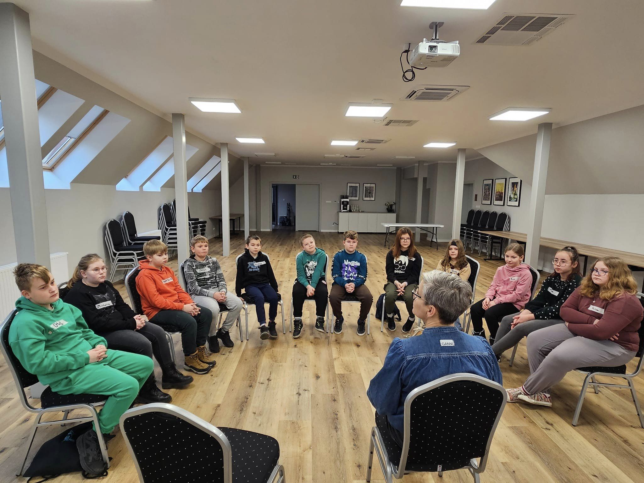 Dzieci siedzą na krzesłach